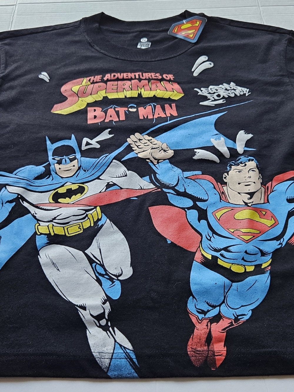 black DC Comics graphic t-shirt featuring a vintage-style action graphic of Supe